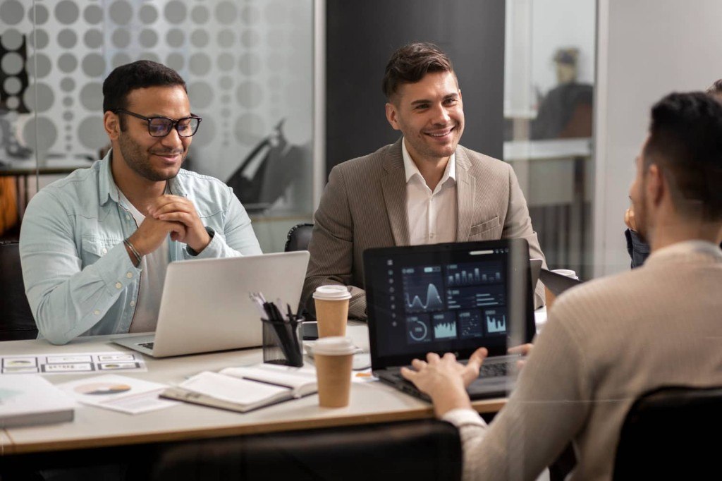 AI consultant presenting data insights on a laptop to an engaged business team